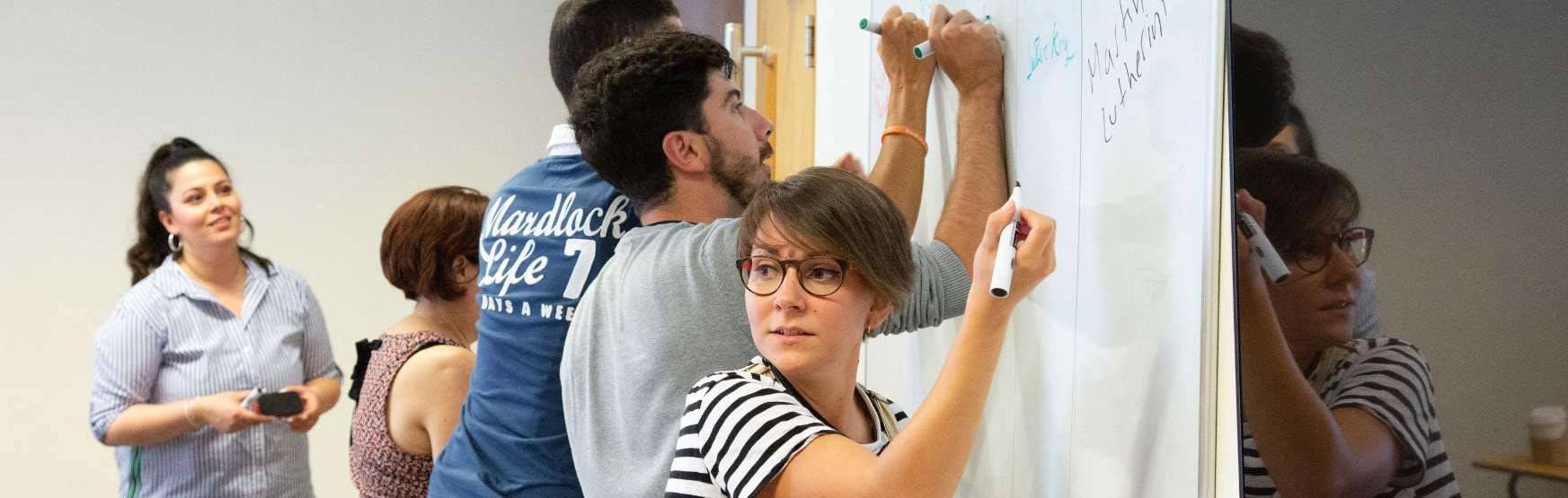 Profesor especializado impartiendo clase de inglés técnico con material profesional